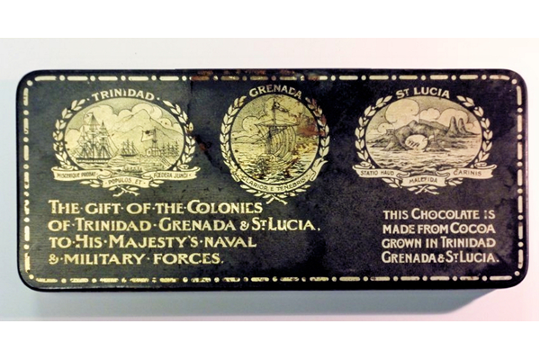 First World War chocolate box sent as a gift to HM forces. The tin bears the emblems of Trinidad, Grenada and St. Lucia and is marked: 'THE GIFT OF THE COLONIES OF TRINIDAD, GRENADA & ST. LUCIA TO HIS MAJESTY'S NAVAL & MILITARY FORCES' and  'THIS CHOCOLATE IS MADE FROM COCOA GROWN IN TRINIDAD, GRENADA & ST. LUCIA.' - 1996.67 - © McLean Museum and Art Gallery, Greenock