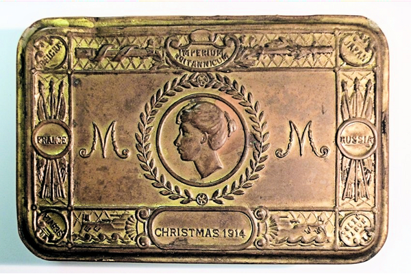 Princess Mary Christmas box for HM forces issued for Christmas 1914. Decorated with Princess Mary's portrait, the initial 'M' and is inscribed 'IMPERIUM BRITANICUM', with the Allied Countries named in the borders: Belgium, Japan, Russia, Montenegro, Servia and France. Inside is a card inscribed: 'With Best Wishes for a Happy Christmas and a Victorious New Year / From the Princess Mary and Friends at Home'. - 1991.18 - © McLean Museum and Art Gallery, Greenock