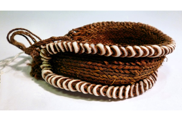 Although said by the donor to be from New Britain it is possible that this item is actually from the Admiralty Islands (Manus Island). It is made of coloured dried grass, yellow, brown and red, with corded tie decorated with a border of small white shells. - 1977.76 © McLean Museum and Art Gallery, Greenock.