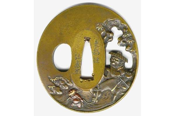 An eighteenth century Japanese swordguard or tsuba. Its is made of yellow bronze and is decorated with a scene sowing an elderly figure following a bullock being led across a river by an oni. Signed by Hiroyasu. - 1981.65 - © McLean Museum and Art Gallery, Greenock