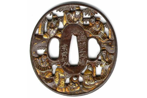 A eighteenth century Japanese swordguard or tsuba. The design  shows a scene depicting the Seven Sages of the Bamboo Grove in openwork. Inscription on both sides. Signed: Soten of Hikone. - 1981.99 - © McLean Museum and Art Gallery, Greenock
