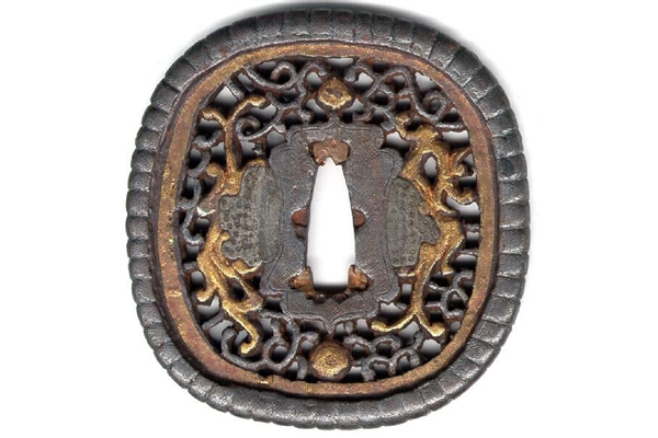 A seventeenth century Japanese swordguard or tsuba. The tsuba is made of iron and has a damascened design in gold and silver based on the Karakusa pattern. - 1981.116 - © McLean Museum and Art Gallery, Greenock