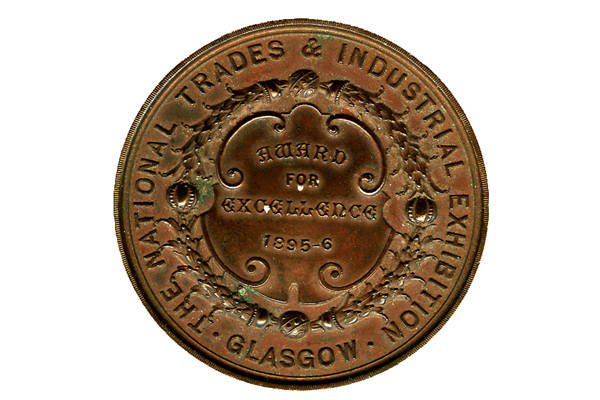 Copper medal of The National Trades & Industrial Exhibition Glasgow 1896 awarded for Excellence to Neil Campbell for the construction of a rowing cutter model. - 2007.888 - © McLean Museum and Art Gallery, Greenock