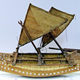 Model of a vaka or outrigger canoe with twin hulls, two sails, double ended, made of carved timber and extensively inlaid with mother-of-pearl discs. The central panelling is made from pandanus fibre. Made at Manihiki in the Cook Islands some time before 1876. - 2009.8 © McLean Museum and Art Gallery, Greenock.