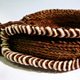 Although said by the donor to be from New Britain it is possible that this item is actually from the Admiralty Islands (Manus Island). It is made of coloured dried grass, yellow, brown and red, with corded tie decorated with a border of small white shells. - 1977.76 © McLean Museum and Art Gallery, Greenock.