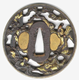 A Japanese swordguard or tsuba, date unknown. The design shows Soki and an attendant under a pine tree with a waterfall. Inscription on both sides. The rim of the tsuba is gilded. - 1981.1156 - © McLean Museum and Art Gallery, Greenock